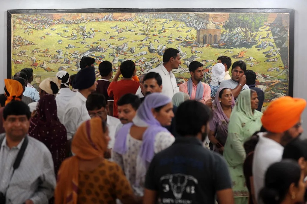 Indian visitors in Amritsar in 2011 look at a painting depicting the Jallianwala Bagh massacre Photo Credit: Narinder Nanu—AFP via Getty Images